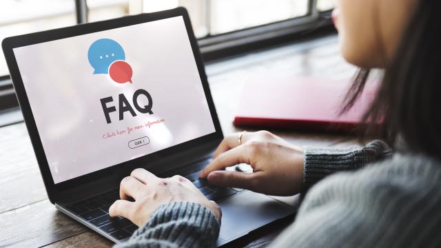Person using laptop with FAQ on screen