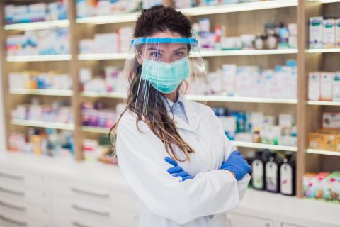 A pharmacist wearing a face mask and a face shield