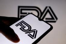 Hand holding a smart phone with the FDA logo on the screen