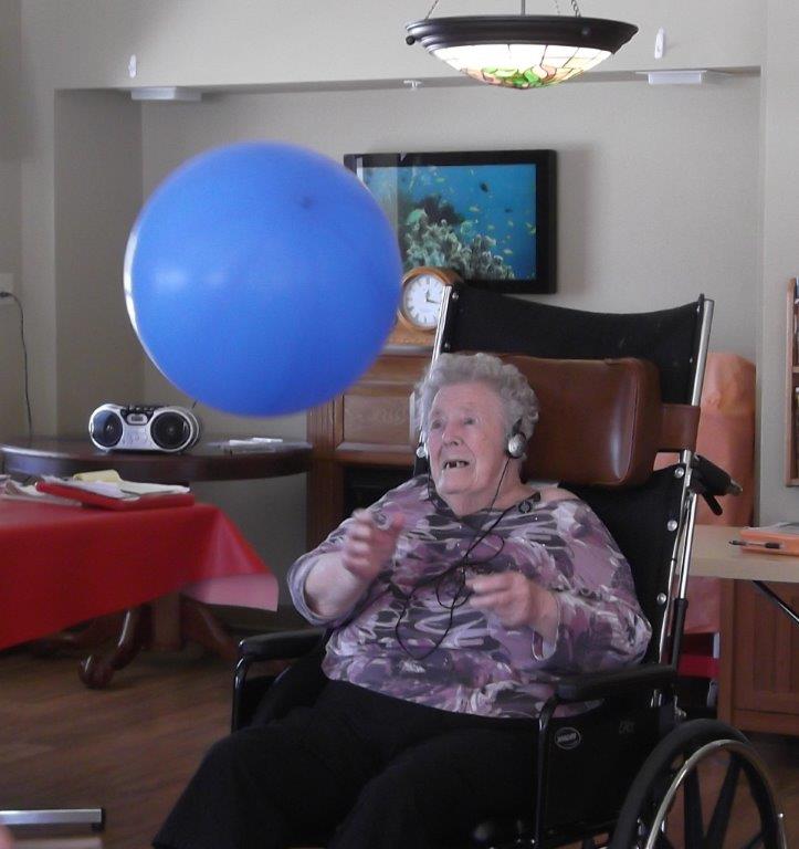 Elsie listens to music with a blue ball in the air as part of Music and Memory Program.