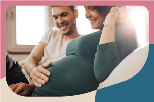 Sitting couple, Person with hand on pregnant person's belly, no logo