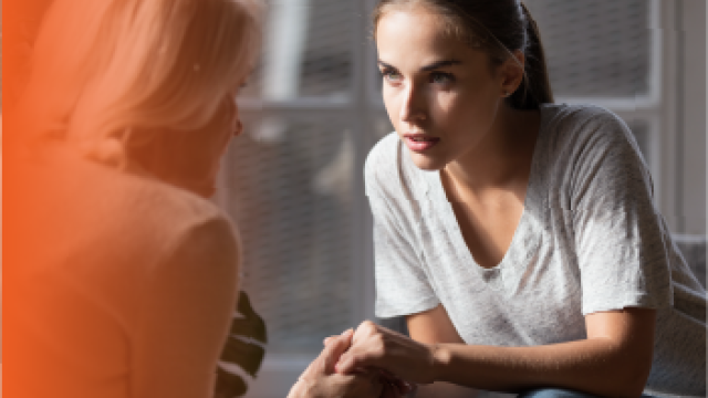 Two people in conversation holding hands