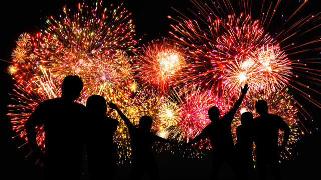 Silhouette of people viewing fireworks