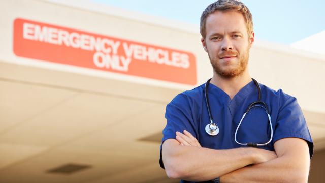 Smiling doctor standing in front of hospital