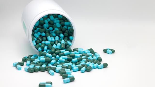 Bottle of spilled green and blue antibiotic pills