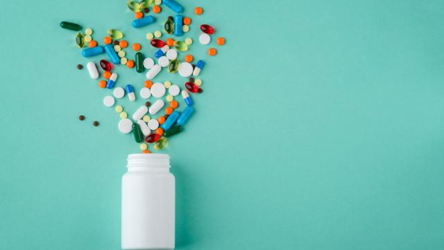 Multi-colored pills spilling out of a pill bottle look like flowers.