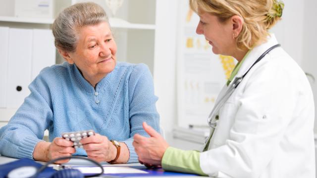 Physician talks to an elderly person about medications with blood pressure meter in the front