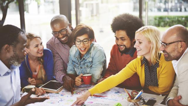 Group of adults around a conference table discussion communications plans