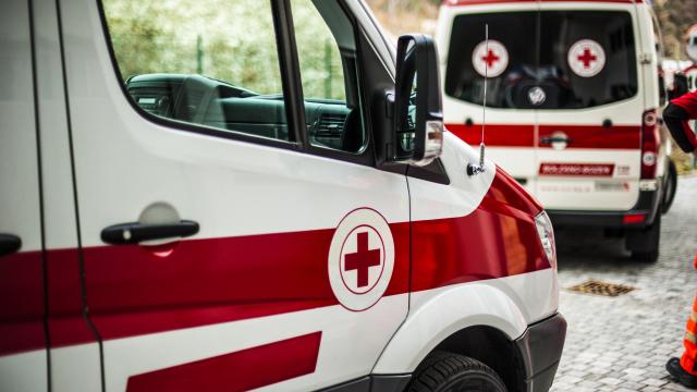 Two ambulances with red cross emblem on the passenger doors.