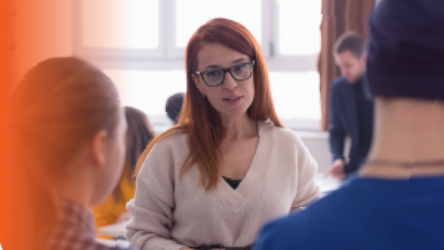 Person talking with two other people in a room