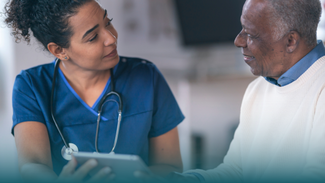 health professional holding clipboard consults with senior patient