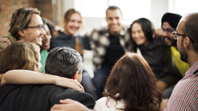 Happy adults in a group hug.