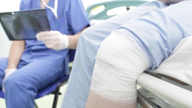 Doctor holding x-ray with patient who has a knee injury