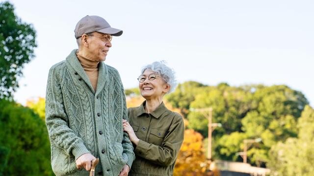 Older couple stand in a park