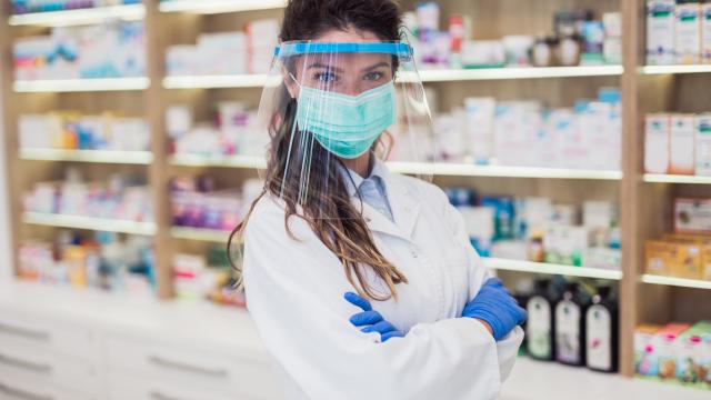 A pharmacist wearing a face mask and a face shield