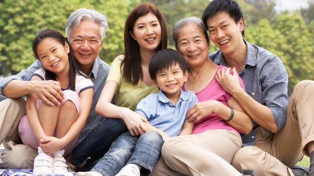 Three generation family poses in a park