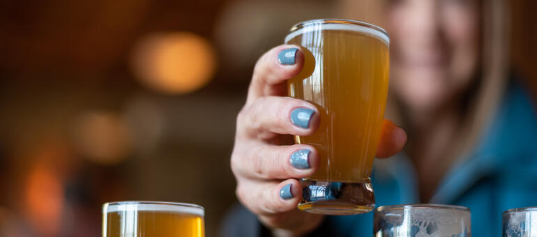 Glass of beer held by an adult