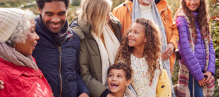 A multigenerational family wearing coats outside