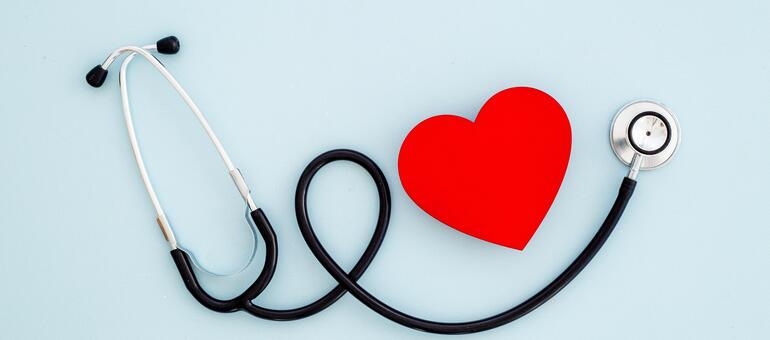 Stethoscope with red heart on light blue background