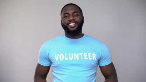Adult wearing a blue volunteer shirt
