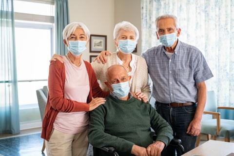Four older adults wearing masks