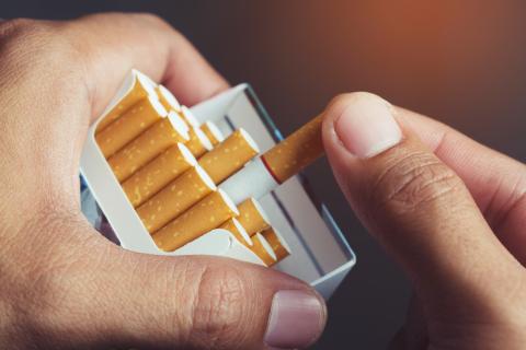 Hand holding a pack of cigarettes