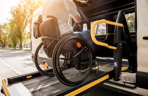 Person in a wheelchair entering a vehicle using a lift