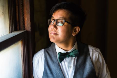 Young adult looking out a window