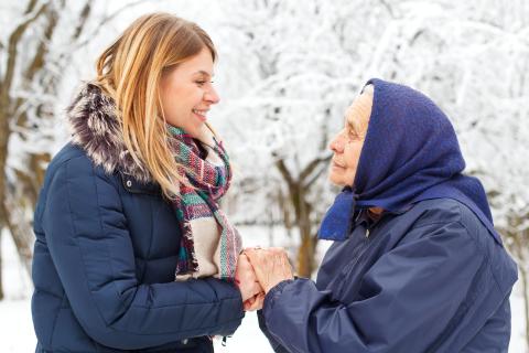 Two adults hold hands outside in winter.