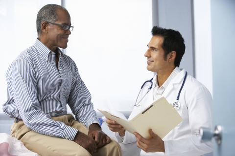 Doctor talking to patient while holding file folder