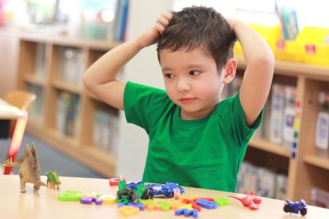 Child playing with toys on a library table