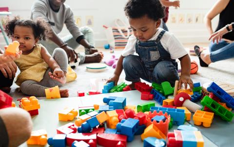 Children playing with legos on the floor