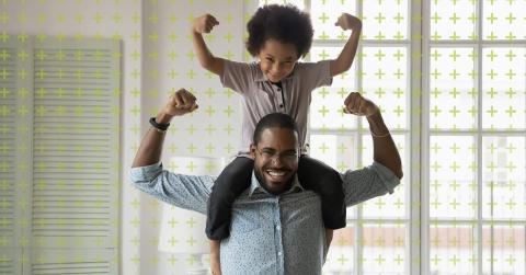 Adult with child on shoulders showing muscles