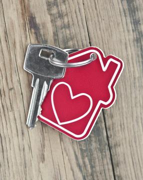 A red house tag with a heart with a key attached to it.