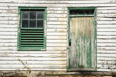 White house with green trimmed showing peeling lead paint