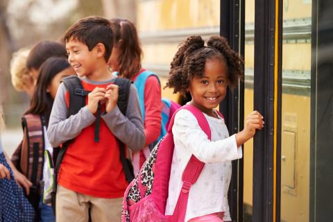 Young children getting on a school bus