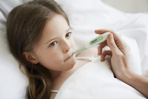 Young child is having her temperature taken in bed