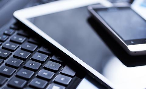 Keyboard with a tablet and smart phone laying on it