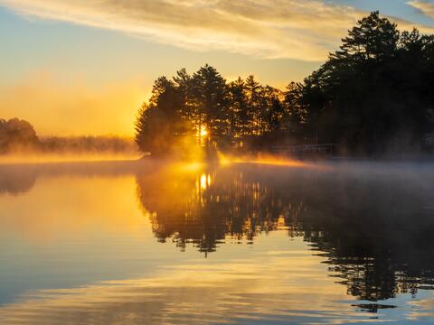 Sunrise on a lake with mist along the shoreline