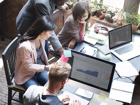 A teamwork of four adults on a table.