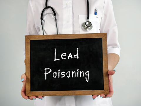 Doctor holding a lead poisoning sign