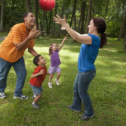 Family of four playing ball outside