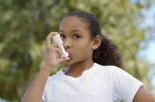 A child uses an inhaler outside