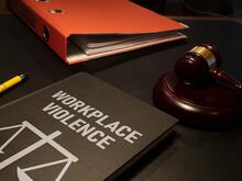 Table with a gavel, binder and workplace violence book