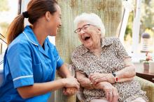 Older adult laughing with caregiver