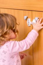 Toddler trying to open child proofed cabinet