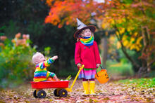 A young child dress up with a toddler in a wagon for Halloween.