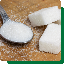 Spoon of sugar next to several sugar cubes