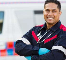 Adult with folded arms standing in front of a vehicle