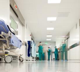Hospital corridor with staffs in green scrubs